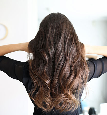 Femme avec une coupe de cheveux longs et ondulés